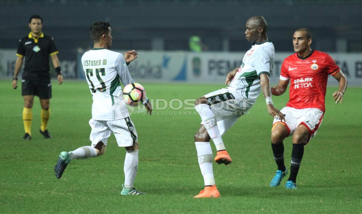 Bek PS TNI, Franklin Anzite Touadere (tengah) menghalau serangan pemain Persija Jakarta. Herry Ibrahim/INDOSPORT Copyright: Herry Ibrahim/INDOSPORT